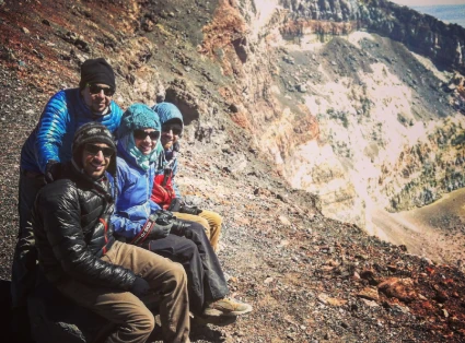 Group of 4 mountaineers on the summit of Volcán Láscar, near the crater.