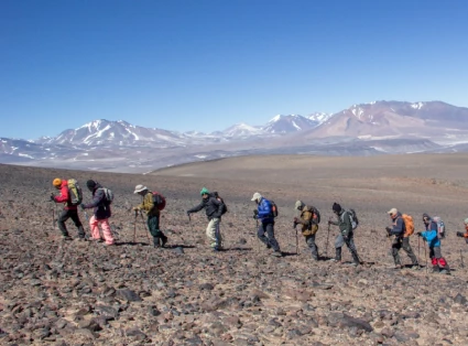 Group of mountaineers walking towards the Ojos del Salado mountain.