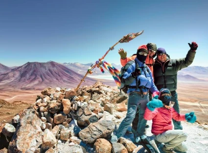 Group of 4 mountaineers on the summit of Tocko Volcano