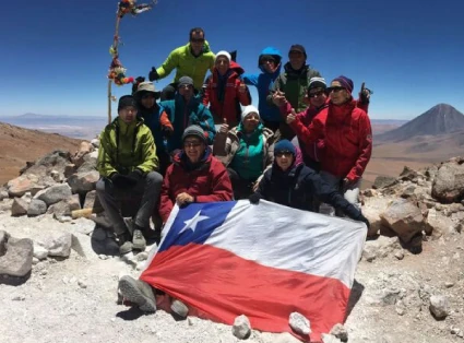 Group of 12 mountaineers on the summit of Tocko Volcano